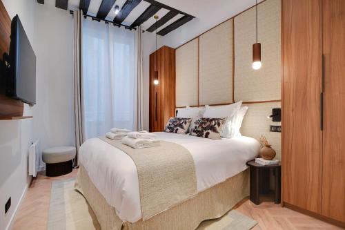 une chambre avec un grand lit et une télévision dans l'établissement Luxury in the heart or Paris-Notre Dame, à Paris