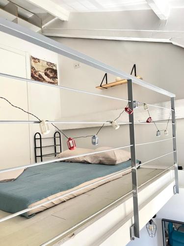 Ce lit se trouve dans un dortoir doté de murs et d'étagères blancs. dans l'établissement Duplex heart of Cannes with terrace, à Cannes