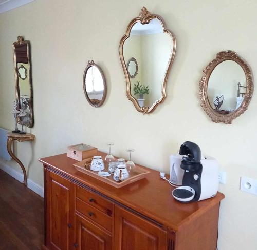 a wooden dresser with a coffee maker and mirrors at Le Potier Jovial in Ger