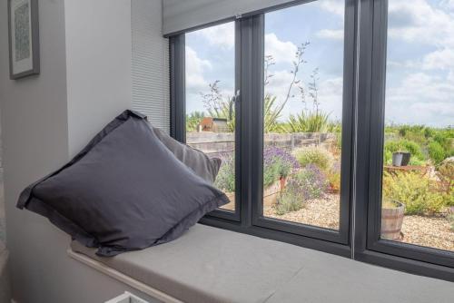 a pillow sitting on a window sill looking out at a garden at Seafront BnB at Botany in Kent