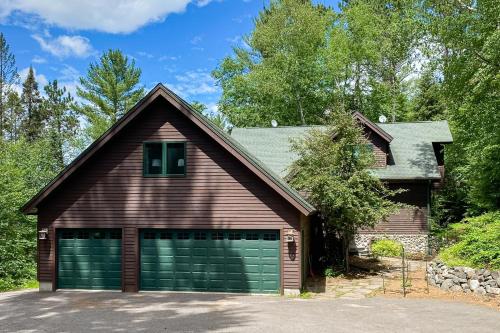 a brown house with a garage at Hidden River Lodge in Eagle River