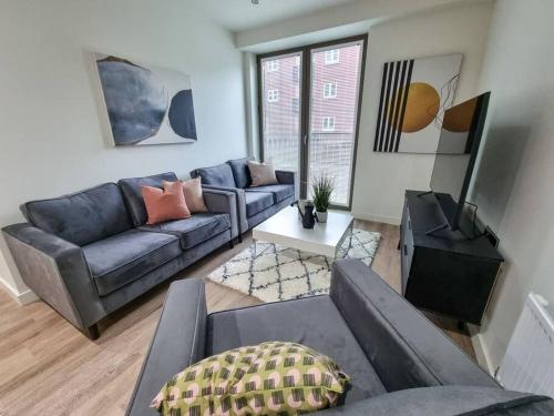 a living room with a couch and a table at Stunning 4-bedroom Townhouse with Free Parking in Manchester