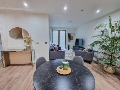 a living room with a black table and chairs at Stunning 4-bedroom Townhouse with Free Parking in Manchester