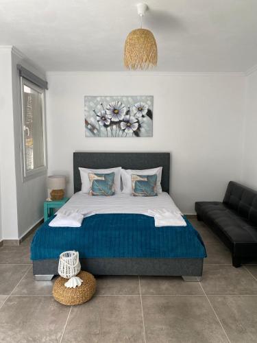 a bedroom with a large bed and a couch at Yaya house in Skala Sotiros
