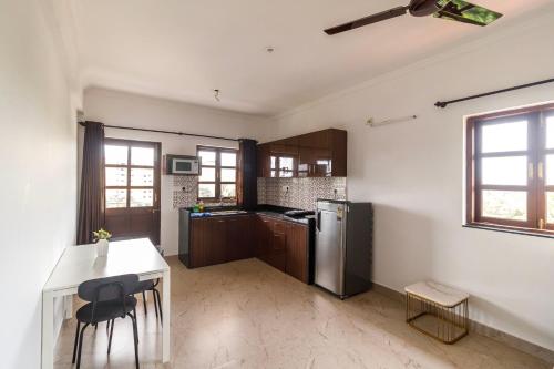 a kitchen with a refrigerator and a table and chairs at Casa Quina in Panaji