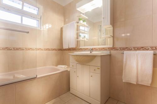 a bathroom with a sink and a tub and a mirror at Jango Paradise in Funchal