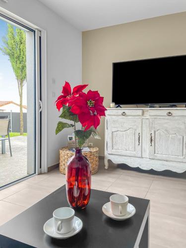 un vase avec une fleur rouge assise sur une table dans l'établissement gîte de Marko et Mag à Oudon, à Oudon