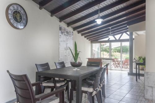 a dining room with a table and chairs and a clock at Jango Paradise in Funchal