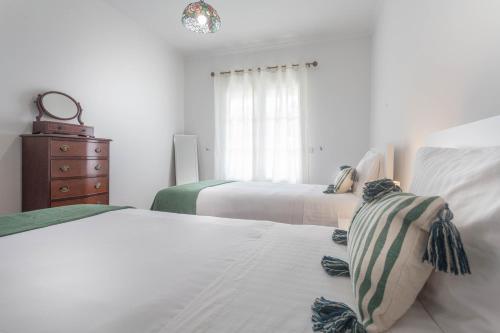 a bedroom with two beds and a dresser and a window at Jango Paradise in Funchal
