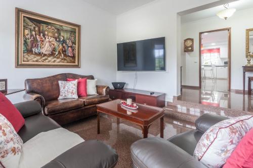 a living room with leather furniture and a flat screen tv at Jango Paradise in Funchal