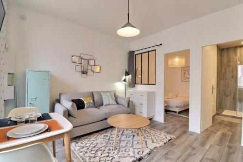 un salon avec un canapé et une table dans l'établissement Le Péri - T1 Apartment 4 Guests - Villeurbanne, à Villeurbanne