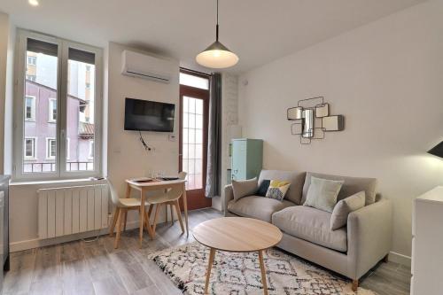 un salon avec un canapé et une table dans l'établissement Le Péri - T1 Apartment 4 Guests - Villeurbanne, à Villeurbanne