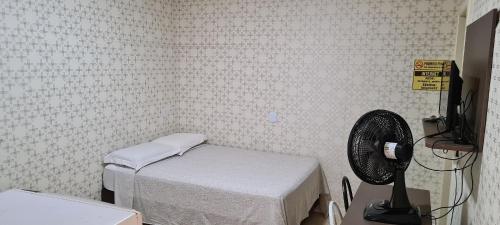 a hospital room with a bed and a fan at Locapart Hospedagens - Centro in Chapecó