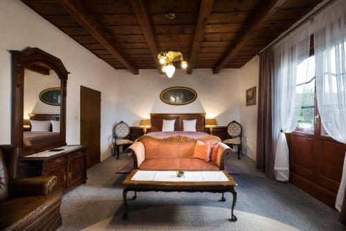 a bedroom with a bed and a table and a mirror at Penzión Villa Breza in Smokovce