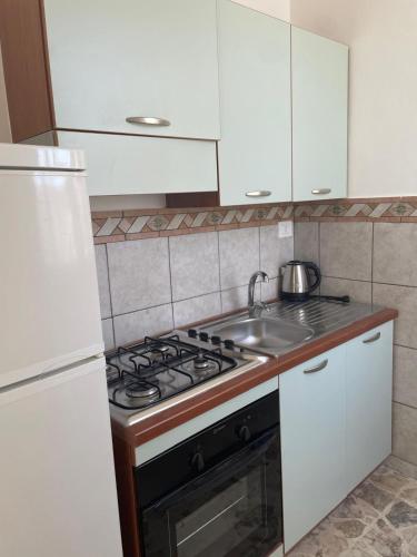 a kitchen with a stove and a sink at VENTINOVE Apartments in Otranto