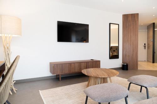 a living room with a table and two chairs and a tv at AP Cabanas Beach & Nature - Adults Friendly in Cabanas de Tavira