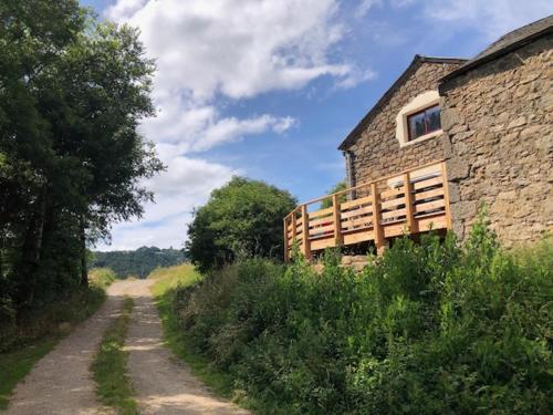 a dirt road next to a stone building at La Jasse in Saint-Beauzély