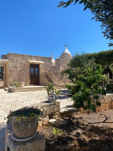 a stone building with some potted plants in front of it at Dimore Storiche - Ulivo di Aldo in Martina Franca