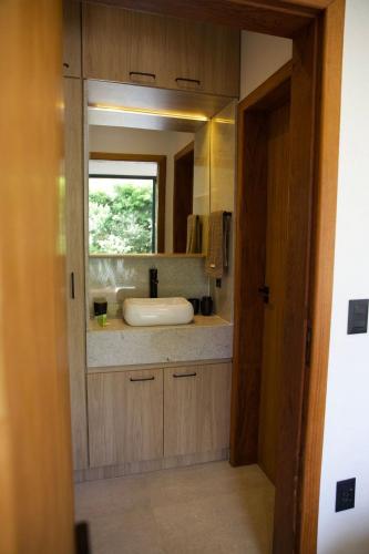 a bathroom with a sink and a mirror at Casa Nengueta - Lapinha da Serra in Santana do Riacho