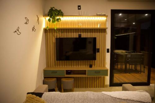 a living room with a flat screen tv on a wall at Casa Nengueta - Lapinha da Serra in Santana do Riacho