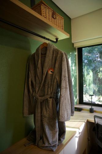 a robe hanging on a kitchen counter next to a window at Casa Nengueta - Lapinha da Serra in Santana do Riacho