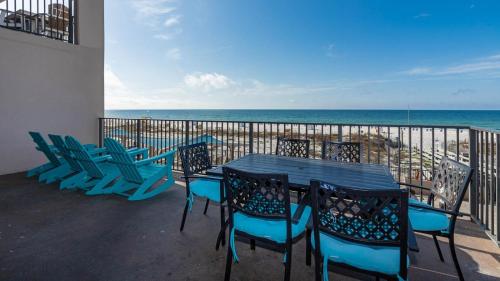 a table and chairs on a balcony with the ocean at Phoenix X 212 condo in Orange Beach
