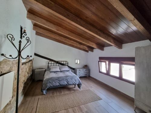 a bedroom with a bed and a wooden ceiling at Alojamiento Rural El Pontón in Pontones