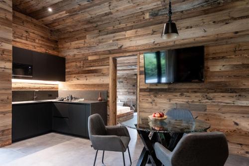 a kitchen and dining room with wooden walls at Ledarix Charm Chalet in Ledro