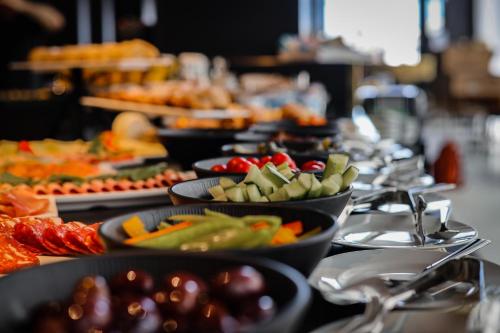 a buffet line of plates of food on a table at Verdi Gzira Promenade in Sliema