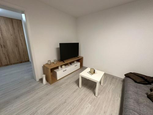 a living room with a television and a table at Elara in Burgrieden