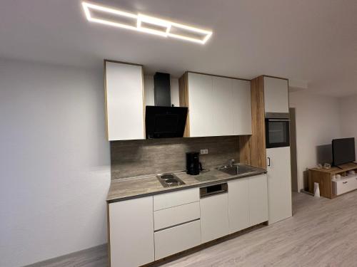 a kitchen with white cabinets and a sink at Elara in Burgrieden