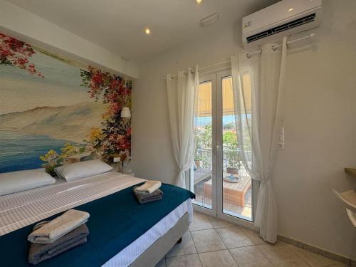 a bedroom with a bed with a painting on the wall at Reginas studios & apartments - Bougainvillea Suite in Fiskardho