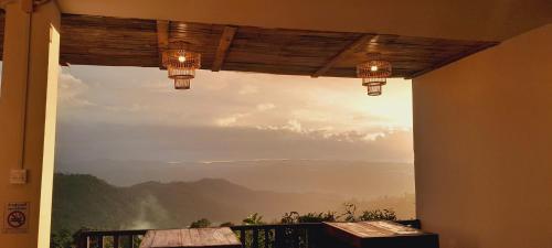 a window with a view of a mountain view at KHIRI HOUSE &Café Farm ดอยช้างเชียงรายที่พักอาข่าเรียวกังสไตล์กลางหมู่บ้านดอยช้าง in Ban Rong Than