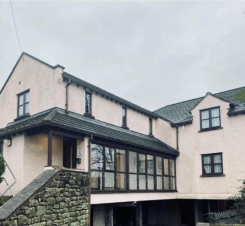 a large white house with a stone wall at The County Lodge in Carnforth