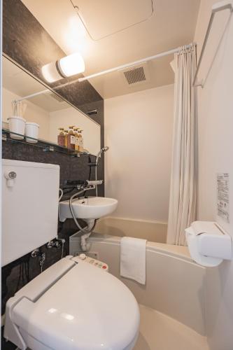 a bathroom with a white toilet and a sink at Elite Inn Kyoto Station エリートイン京都駅 in Kyoto