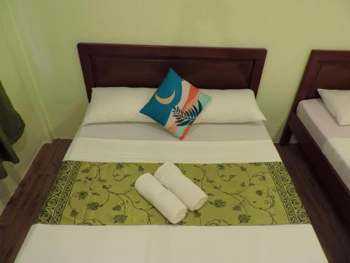 a bed with two pillows on top of it at Chekesh Casa in Siquijor