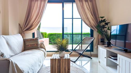 ein Wohnzimmer mit Couch und großem Fenster in der Unterkunft LOS ALTOS sea view apartment in Finestrat