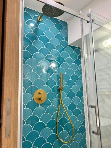 La salle de bains est pourvue d'un mur aux motifs bleus et blancs. dans l'établissement Cosy studio - A 2 pas de Paris et de Versailles, à Louveciennes