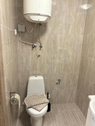 a bathroom with a toilet and a light above it at Апартаменти ЖК Рів'єра in Kyiv