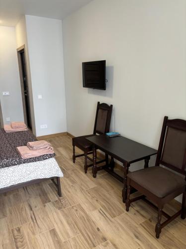 a room with a table and two chairs and a tv at Апартаменти ЖК Рів'єра in Kyiv