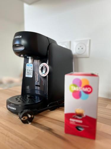une cafetière à côté d'une boîte sur une table dans l'établissement Appartement cosy Paris, à Bagnolet