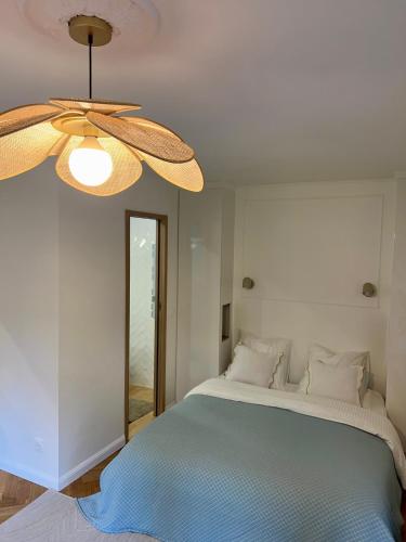 une chambre avec un grand lit avec un ventilateur de plafond dans l'établissement Cosy studio - A 2 pas de Paris et de Versailles, à Louveciennes