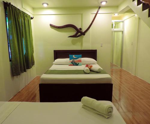 a bedroom with a large bed with a green curtain at Chekesh Casa in Siquijor