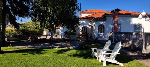 two white chairs in front of a house at Casa da Real Companhia in Lamego