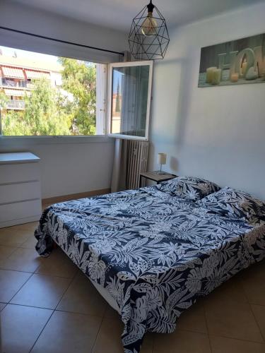 une chambre avec un lit et une grande fenêtre dans l'établissement Grand T2 ensoleillé - Proche Gare, à Hyères