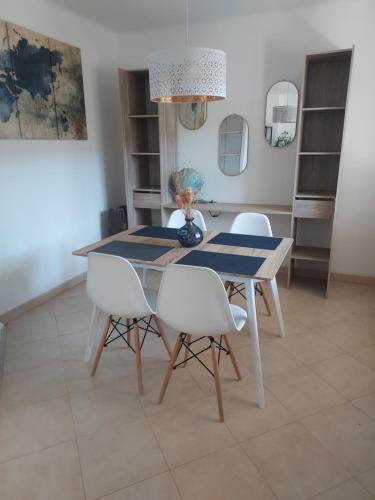 une salle à manger avec une table et des chaises blanches dans l'établissement Grand T2 ensoleillé - Proche Gare, à Hyères