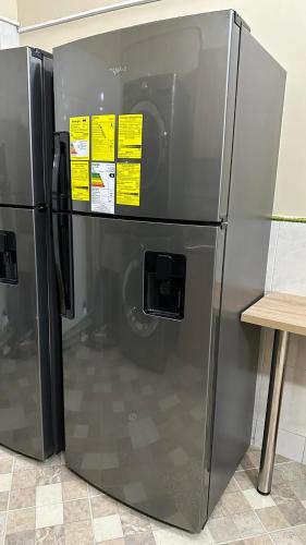 a stainless steel refrigerator with yellow sticky notes on it at Hostelfc Usaquen in Bogotá