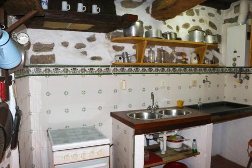a small kitchen with a sink and a stove at Casa da Tia Augusta in Castro Daire