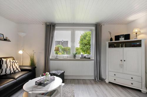 a living room with a couch and a window at Nordsee-Ferienwohnung Halligland in Bredstedt