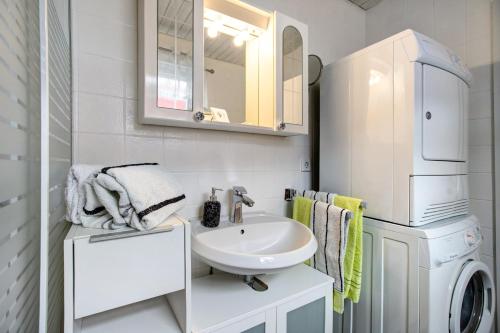 a bathroom with a sink and a washer and dryer at Nordsee-Ferienwohnung Halligland in Bredstedt